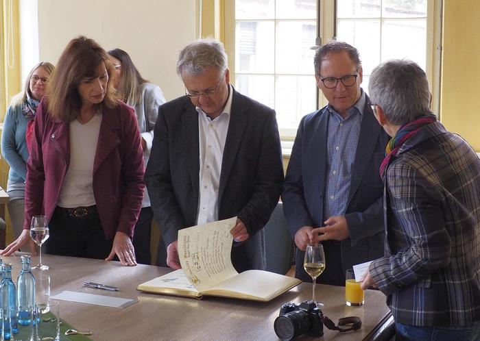 mehrere Menschen im Gespräch im historischen Rathaus
