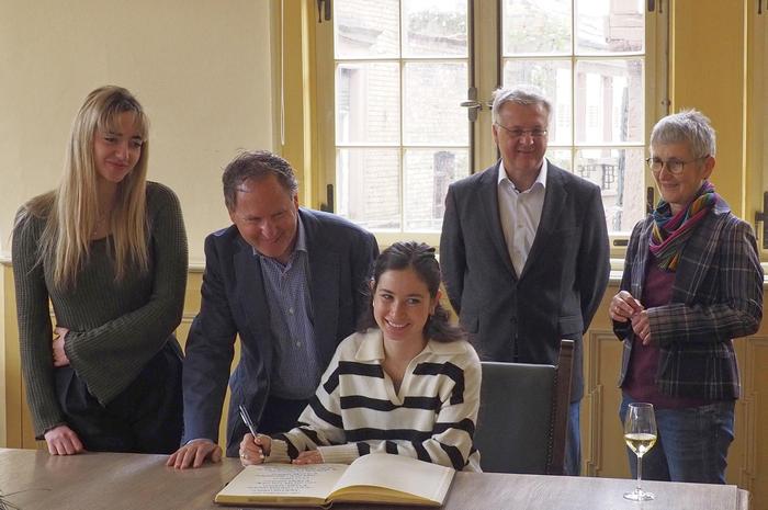 zwei Generationen unterschreiben das Goldene Buch im Rathaus