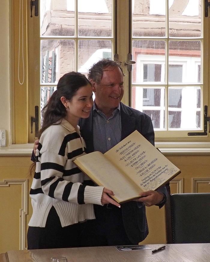 Vater und Tochter halten das unterschriebene Goldene Buch