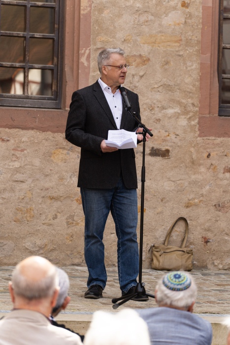 Mann spricht am Mikrofon