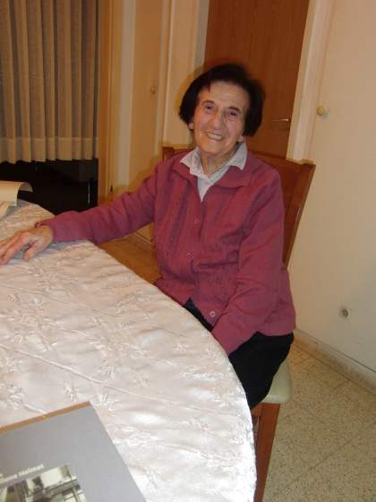 Woman in red cardigan sitting at table in living room