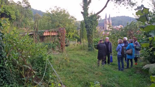 Menschengruppe im Garten, Kirche im Hintergrund