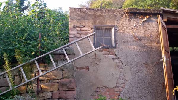 Zerfallene Hauswand mit Leiter